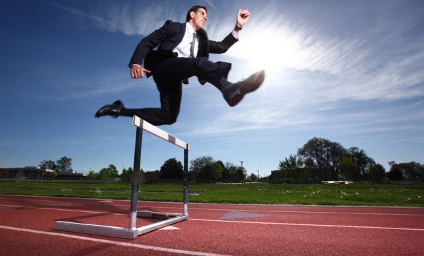 businessman jumping a track hurdle