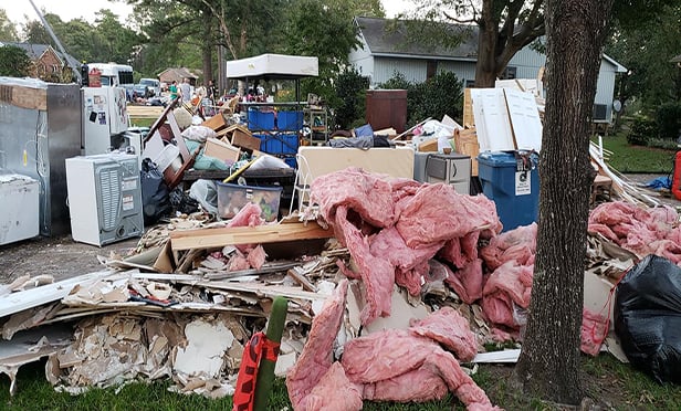 Damaged personal property and debris from a gutted dwelling sit outside a house in River Bend, N.C. The home and neighborhood were devastated by Hurricane Florence. (Contributed photo: L. R. LaMotte)