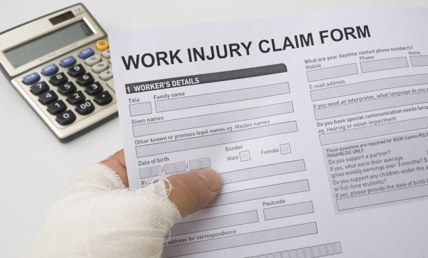 injured worker holding workers' comp claim form