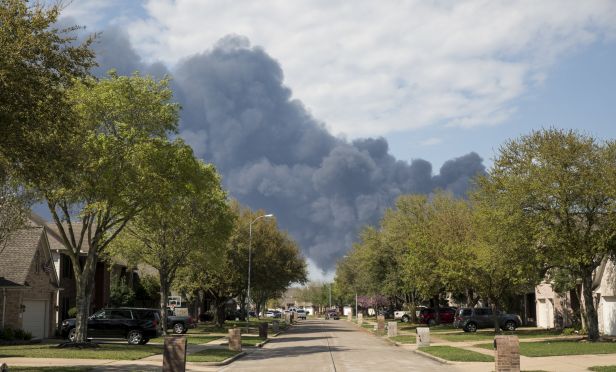 A plume of smoke rises above homes