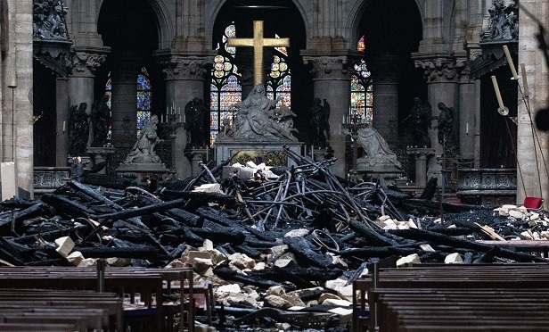 Fallen debris from the burnt out roof structure sits near the high altar inside Notre Dame Cathedral in Paris, France, on Tuesday, April 16, 2019. Authorities declared Tuesday morning that the blaze had been contained as firefighters hosed the south side of the transept to cool down the building, and a district around the cathedral was sealed as military and police patrolled the area. (Photographer: Christophe Morin/Bloomberg)