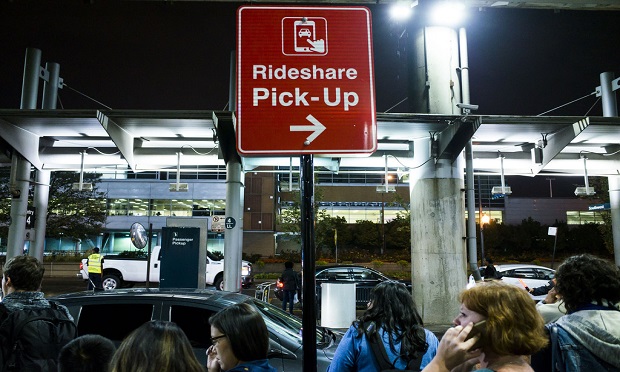 Mobility ecosystems present an opportunity for insurers to step up and catch up when it comes to technology. Here, customers wait for their rides beneath a Rideshare pick-up sign at Chicago's Midway airport. (Diego M. Radzinschi/ALM Media)