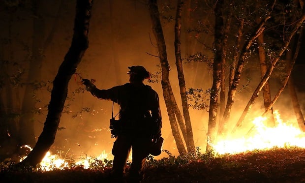 CalFire firefighter Brandon Tolp monitors a firing operation while battling the Tubbs Fire on October 12, 2017 near Calistoga, California. At least thirty one people have died in wildfires that have burned tens of thousands of acres and destroyed over 3,500 homes and businesses in several Northern California counties. (Photo: Justin Sullivan/Getty Images)