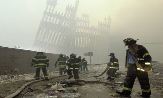 Firefighters work beneath the destroyed mullions, the vertical struts which once faced the soaring outer walls of the World Trade Center towers, after a terrorist attack on the twin towers in New York, on Sept. 11, 2001.