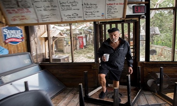 A restaurant owner surveys the damage to his business after a hurricane. (Photo: AP)