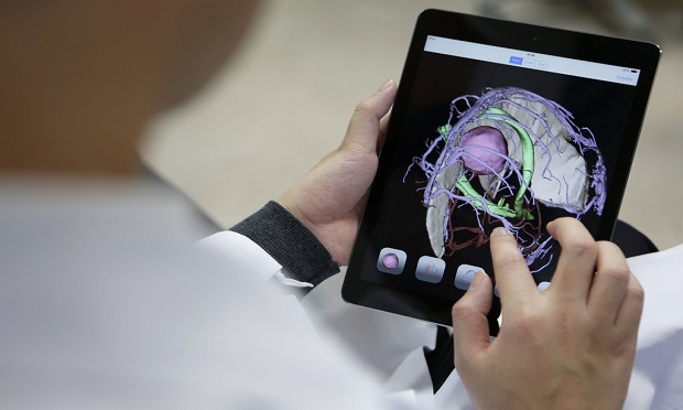 Globally, artificial intelligence applications in health care are raising profound questions about medical responsibility. Here, an associate professor at the University of Toyko inspects 3-D digital images of brain tumor, cranial nerves and blood vessels of a brain scanned and created by a magnetic resonance imaging. (Photo: Kiyoshi Ota/Bloomberg)