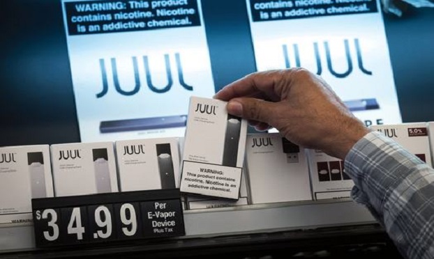 A salesman reaches for a of Juul Labs Inc., device kit for a customer at Discount Cigarettes and Cigars store in San Francisco, California, U.S., on Wednesday, June 26, 2019. The city voted Tuesday to ban sales of e-cigarettes, making it illegal to sell nicotine vaporizer products in stores or for online retailers to ship the goods to San Francisco addresses. Photographer: David Paul Morris/Bloomberg