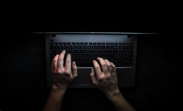 Hacker's hands on a computer keyboard