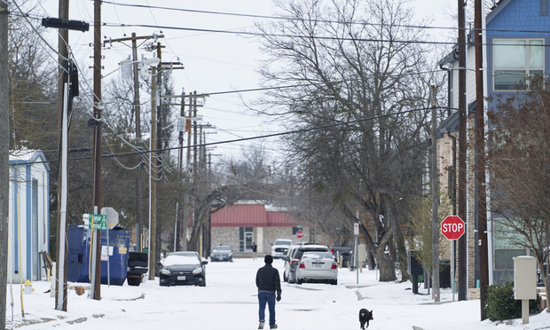 A person walks their dog in McKinney, Texas, on Tues., Feb. 16, 2021. The energy crisis crippled Texas as blackouts left almost millions of people without electricity during the unprecedented freezing weather. (Cooper Neill/Bloomberg)