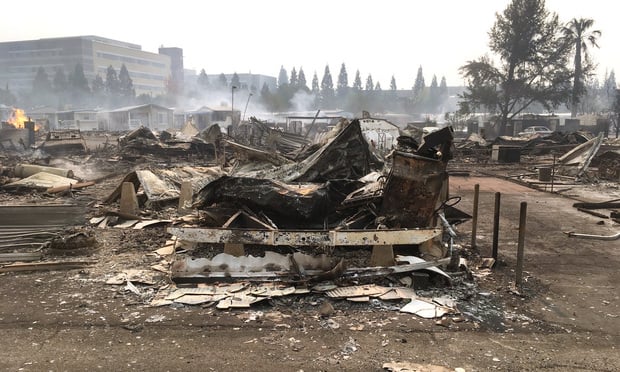 Still-smoldering remains of the Journey's End Mobile Home Park (Tubbs Fire, Santa Rosa, California). The undamaged Kaiser Permanente Santa Rosa Medical Center stands in the background. (Wikipedia Commons)