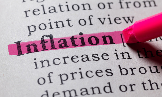 A close-up of a dictionary page with the word "inflation" highlighted in pink ink.