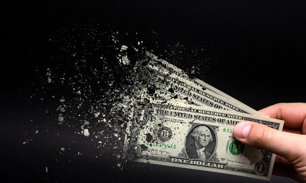 A hand holds two $1 bills in their hand in front of a black background. The bills are disintegrating, as if snapped by Thanos.