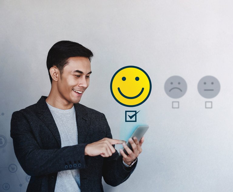 A young person holds their phone as they select a happy face from a series of faces describing how satisfied they are as a customer.