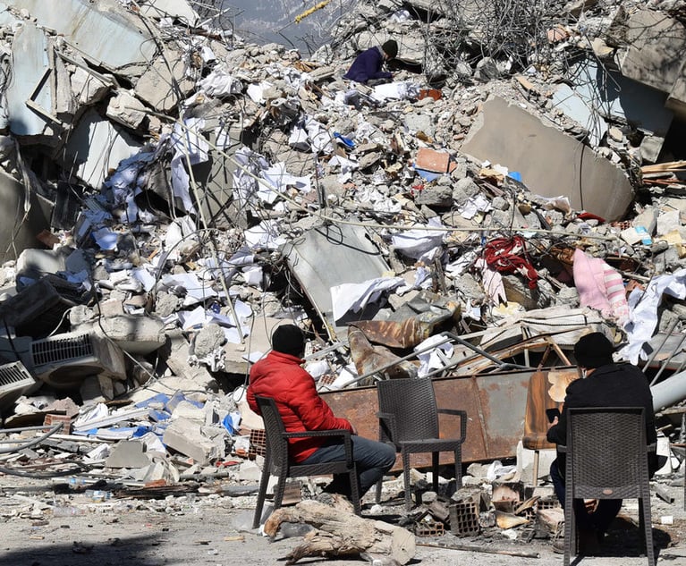 Two people overlook destroyed buildings after the earthquake in Turkey in February 2023.
