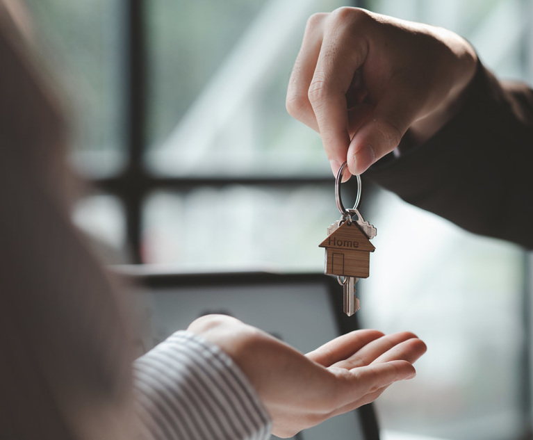 A person handing over a set of house keys to another person.