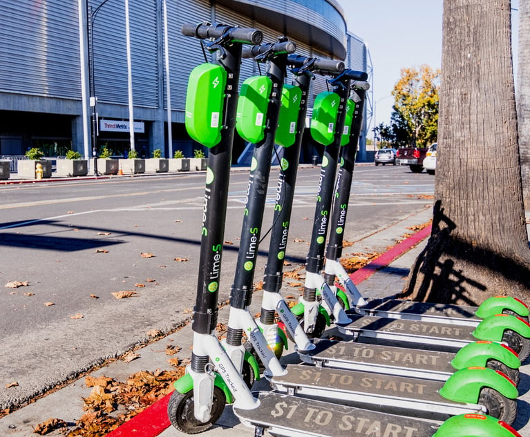 Lime Scooters lined up on a sidewalk in downtown.