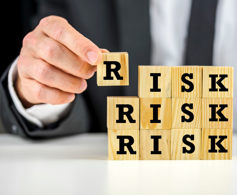 A person stacks letter blocks to spell the word "RISK" three times.