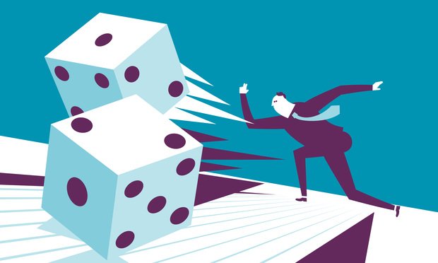Man in a suit rollinggiant dice. Photo: ;iStock.com/akindo