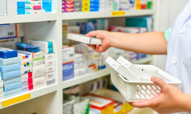 Pharmacist filling prescription in pharmacy drugstore.