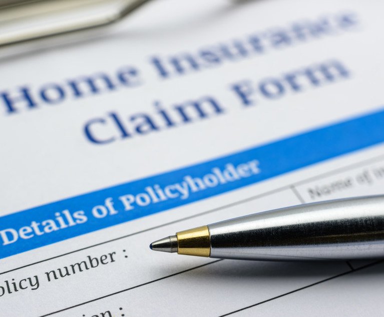 Blue ballpoint pen and a home insurance claim form on a clip board. A blank / empty form is waiting to be filled and signed by a policyholder / insured person.
