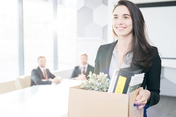 happy woman leaving work with box of belongings