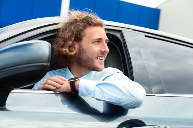 young man in tie in drivers seat