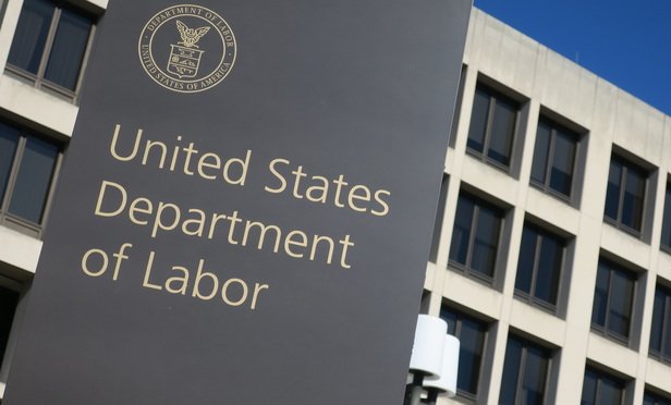 closeup shot of sign in front of DOL building and part of the building