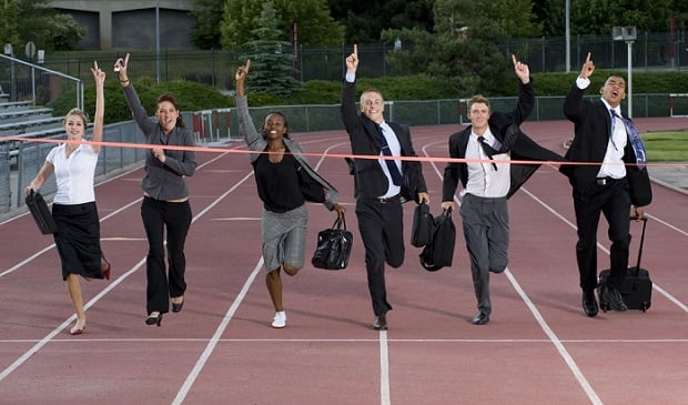 various business people carrying briefcases running together to finish line