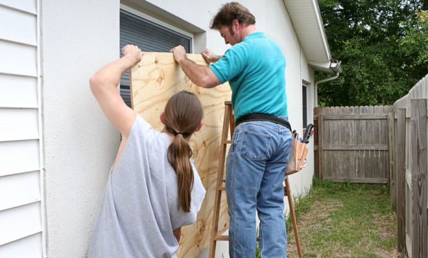 Homeowner boarding up windows.