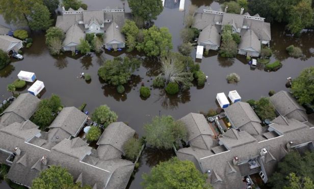 Homes sit in floodwater in a subdivision west of the Ashley river in Charleston, S.C., on Monday, Oct. 5, 2015. (AP Photo/Mic Smith)