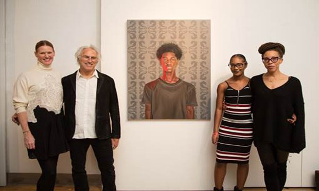 Four people standing with a painting