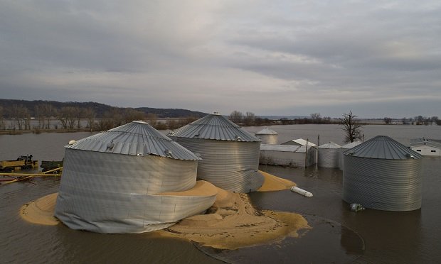 Floodwaters surround corn sitting under a collapsed grain bins in this aerial photograph over Pacific Junction, Iowa, U.S., on Saturday, March 23, 2019. The deluge that devastated so much of the Midwest over the last week could be a preview for one of the worst years for flooding in the U.S., according to federal weather officials. (Photographer: Daniel Acker/Bloomberg)