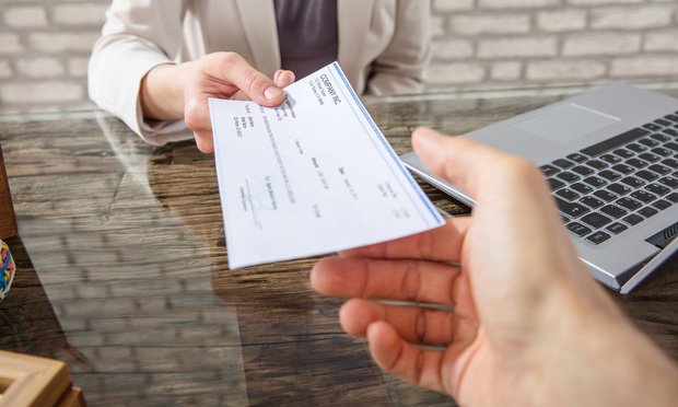 Man handing over a check to another person