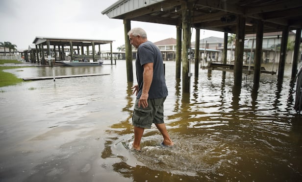 A Myrtle Grove, La., resident assesses flood water damage at a home after a levee breach on Sunday, July 14, 2019. (Photographer: Nicole Craine/Bloomberg)