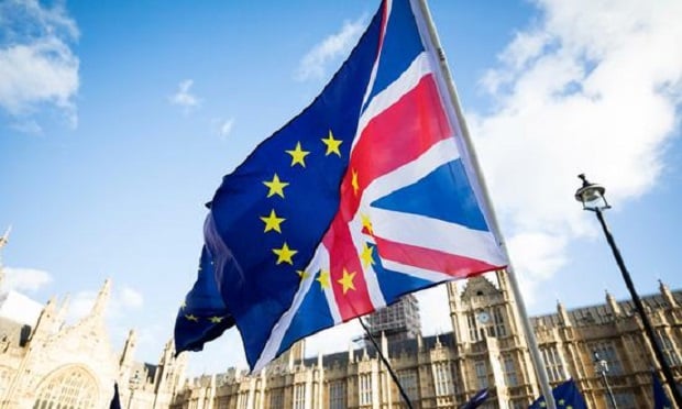 Brexit protesters wave flags made up of a European Union flags and British Union flags, otherwise known as a Union Jack, outside the Houses of Parliament in London, U.K., on Tuesday, Jan. 16, 2018. European Union leaders kept alive the notion of the U.K. reversing its plan to leave the bloc in a sign of lingering hopes that British Prime Minister Theresa May will halt Brexit scheduled for March 2019. Photographer: Chris Ratcliffe/Bloomberg