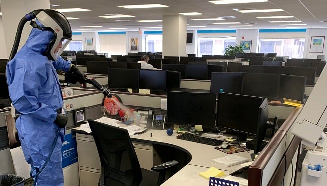 A technician cleans an office for COVID-19.