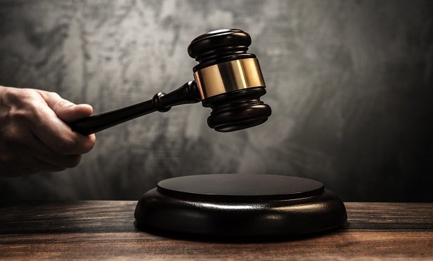 Hand holding a gavel.