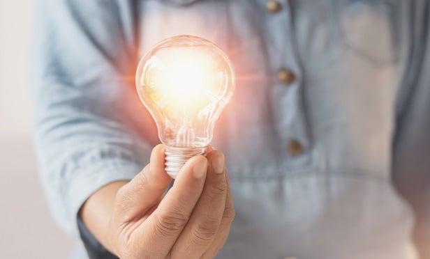 Man holding a lit light bulb.