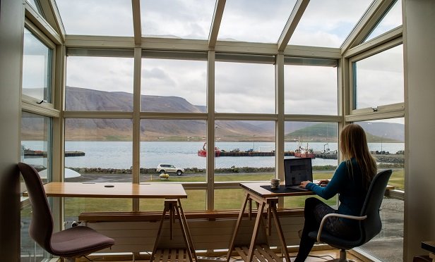 Woman working remotely from her sunroom overlooking the water.