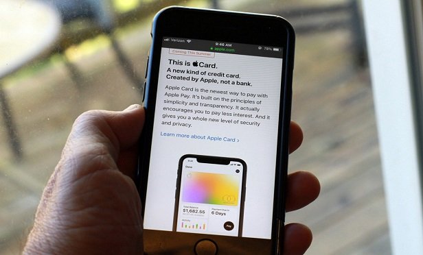 Person holding phone with an Apple Pay app on it.