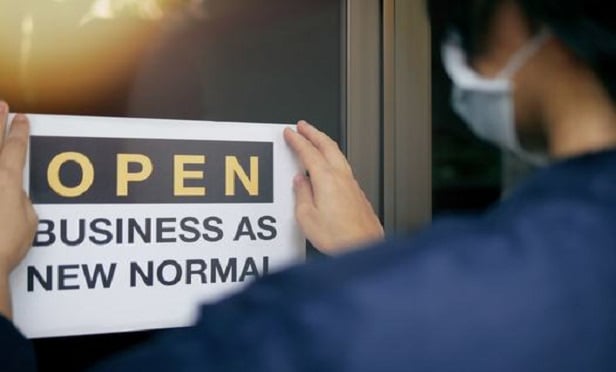 Man posting a reopening sign.