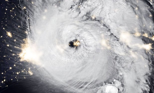 Lights of the city peek out behind the eye of the hurricane.