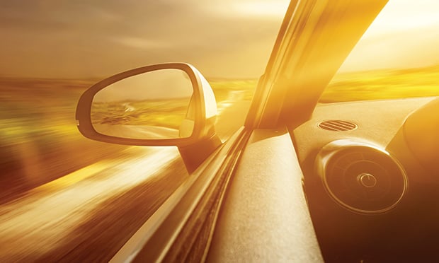 The road in a rearview mirror.