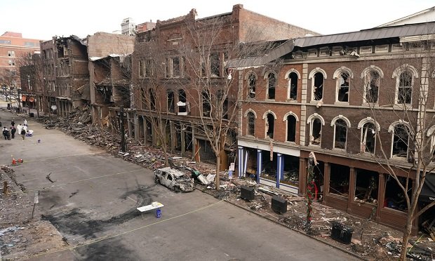 Debris remains on the sidewalks in front of buildings damaged in a Christmas Day explosion Tuesday, Dec. 29, 2020, in Nashville, Tenn. Officials have named 63-year-old Anthony Quinn Warner as the man behind the bombing in which he was killed, but the motive has remained elusive. (AP Photo/Mark Humphrey)