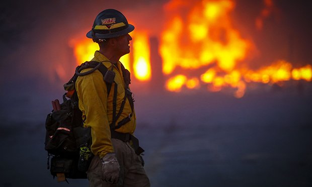 A Mountain View wildland firefighter walks through the smoke and haze after a fast-moving wildfire swept through the area in the Centennial Heights neighborhood of Louisville, Colorado on December 30, 2021. (Credit: Marc Piscotty/Getty Images)