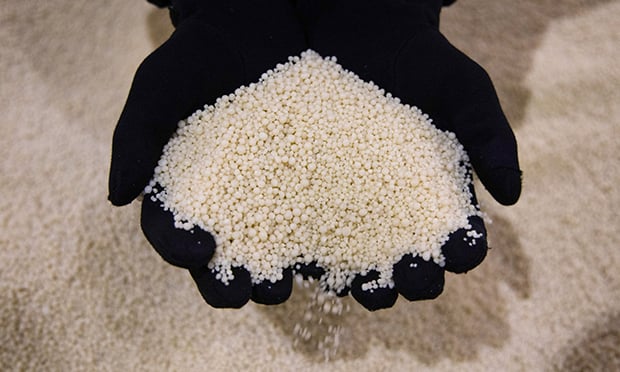 A worker handles phosphate fertilizer (Credit: Andrey Rudakov/Bloomberg)
