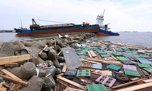 Two ships sit grounded on a breakwater strewn with debris in Hyogo, Japan, after a typhoon, Sept. 6, 2018. (Credit: Buddhika Weerasinghe/Bloomberg)