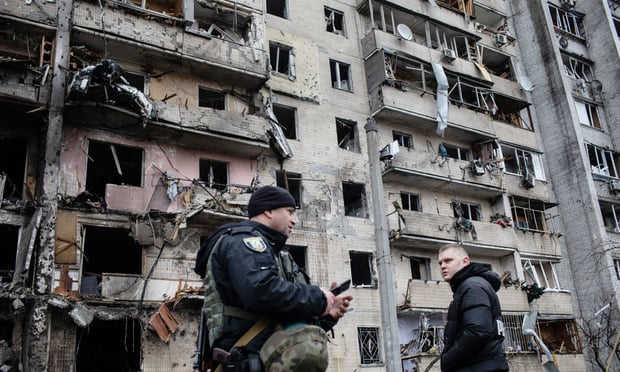 Residents and police inspect a fire damaged building following a blast at around 4am during Russian artillery strikes in Kyiv, Ukraine, on Friday, Feb. 25, 2022. (Credit: Erin Trieb/Bloomberg) 