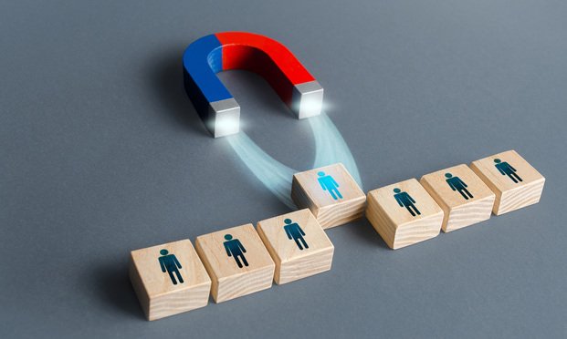 A magnet pulls a block with a person on it out of a row of other similar blocks, as if choosing best candidate for hiring.