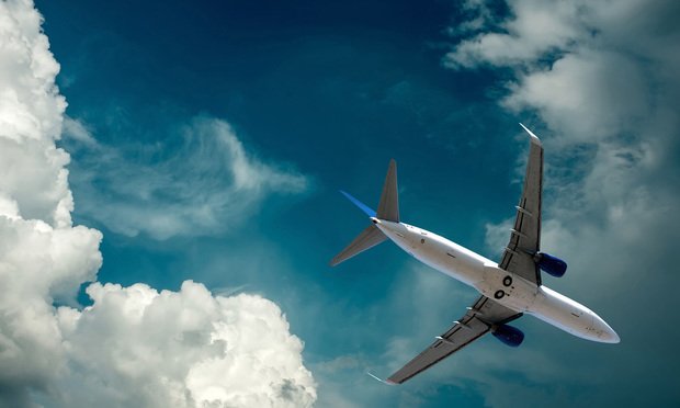 Photo of an in-flight commercial airliner taken from the ground. 